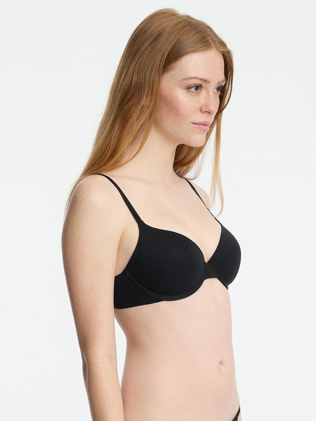 Side view of a model wearing the Insider Convertible T-Shirt Bra in black, showcasing its smooth design and comfort.