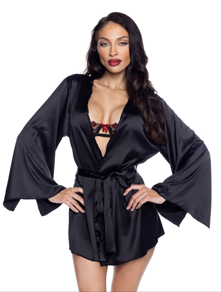 Woman wearing a black satin robe with a red bra and panties set on a white background