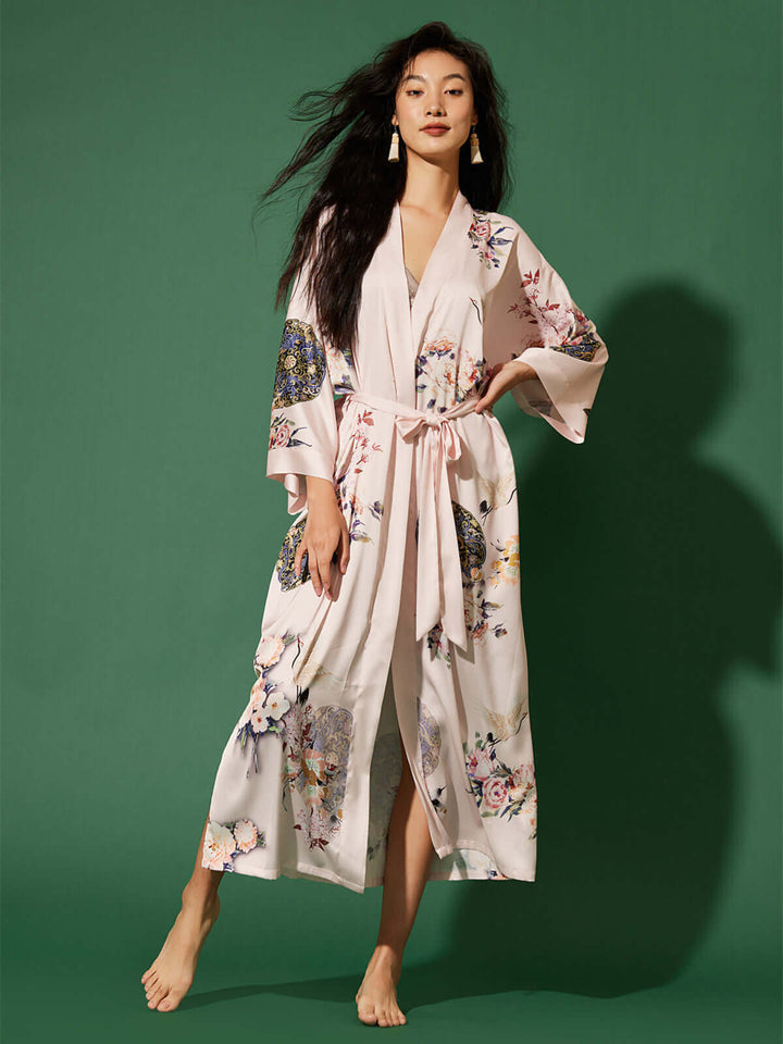 Model wearing the Garden Crane Blush Kimono Robe, featuring hand-painted floral prints and a luxurious design.