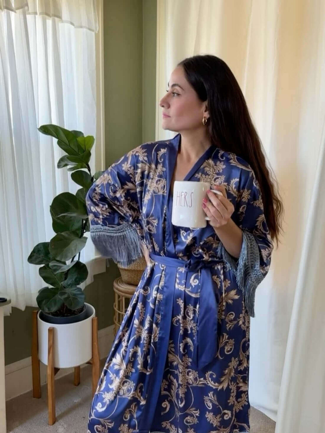 Woman wearing a Tassels Blue Kimono Robe, holding a mug, showcasing luxury and elegance.