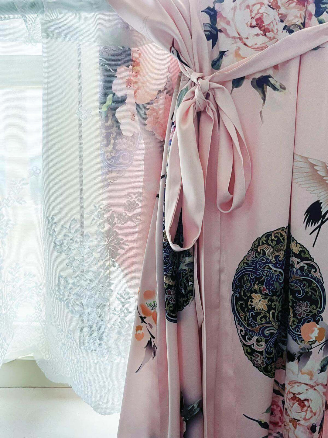Elegant detail of the Garden Crane Blush Kimono Robe, showcasing the luxurious fabric and floral prints.