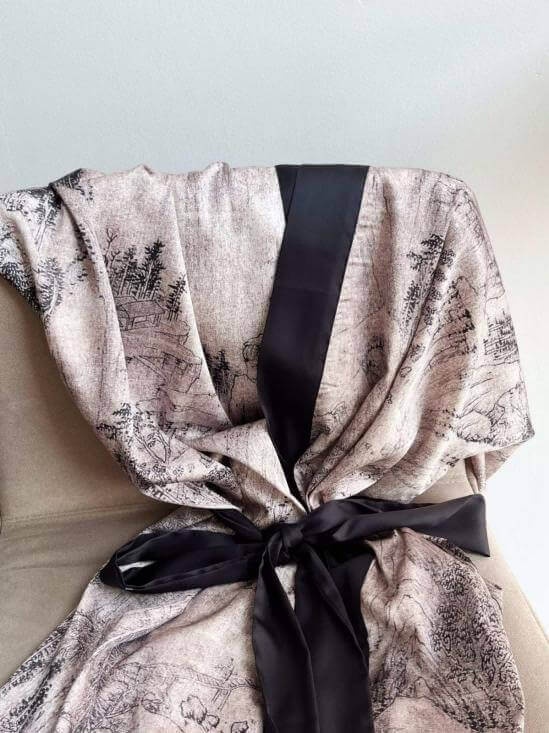 Short Kimono Robe Ink Painting draped elegantly on a chair, showcasing its intricate design and luxurious fabric.