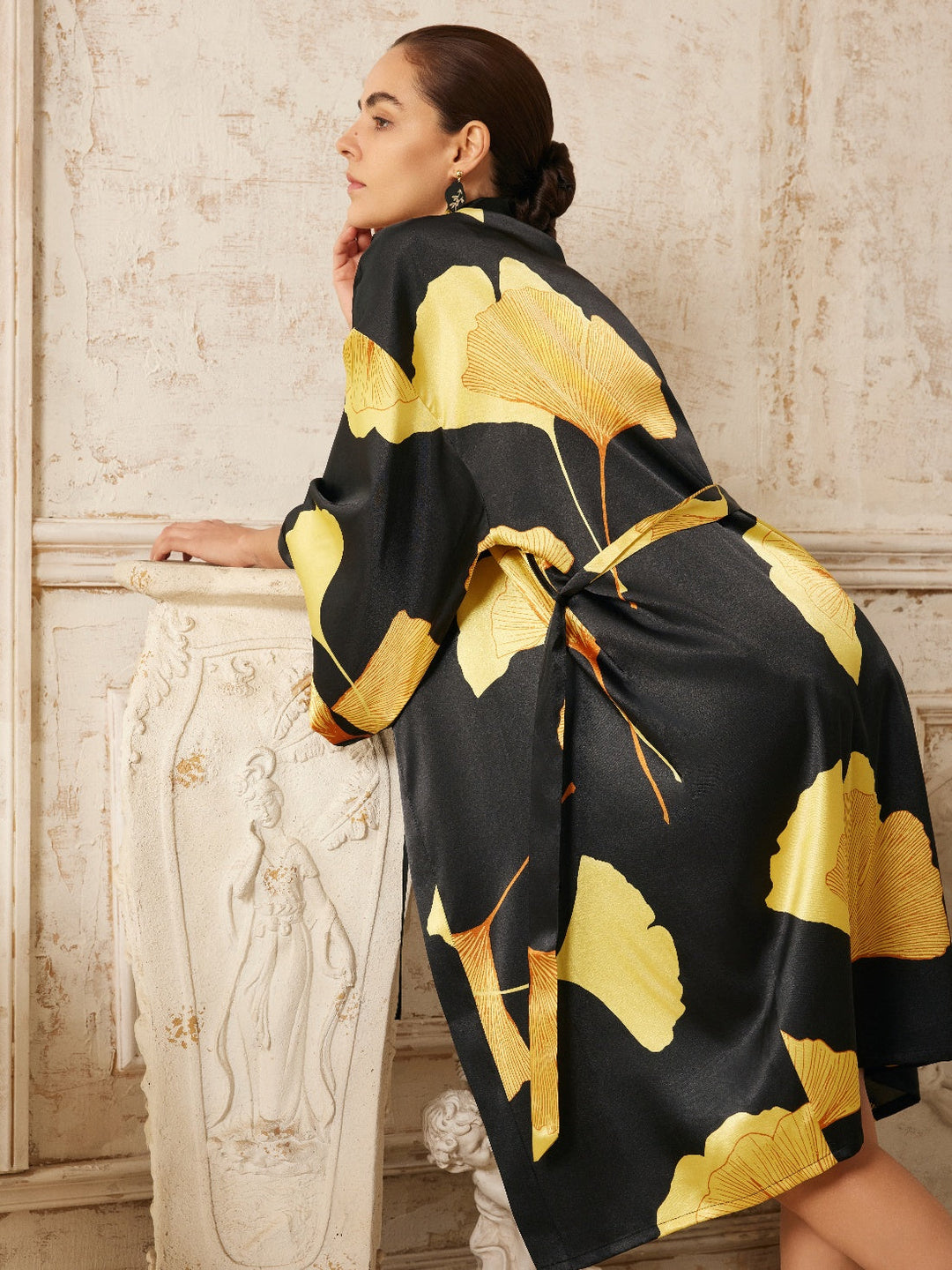 Model showcasing a Yellow Ginkgo Leaf Print Black Kimono Robe against a textured backdrop.