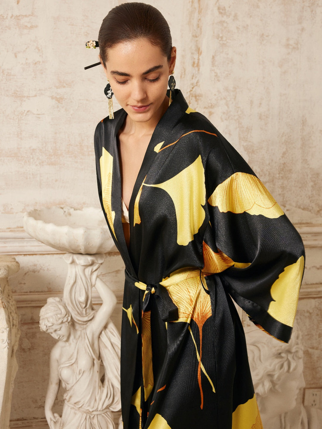 Model wearing a Yellow Ginkgo Leaf Print Black Kimono Robe, showcasing luxury design and elegance in a stylish setting.