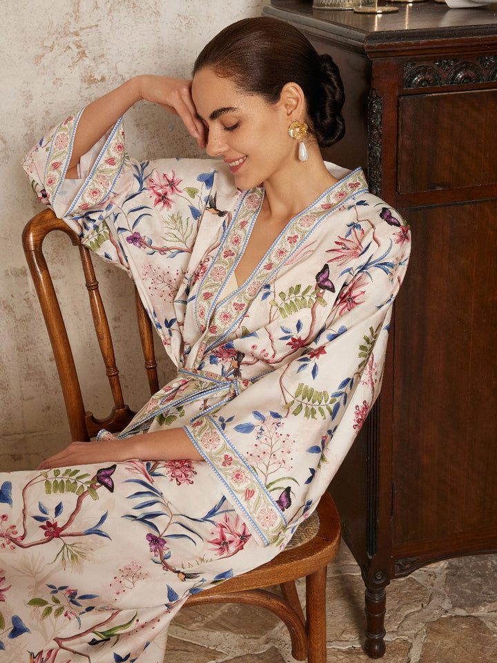 Beige Chinoiserie Floral Long Kimono Robe with Pockets elegantly styled on a seated model, showcasing intricate floral designs.
