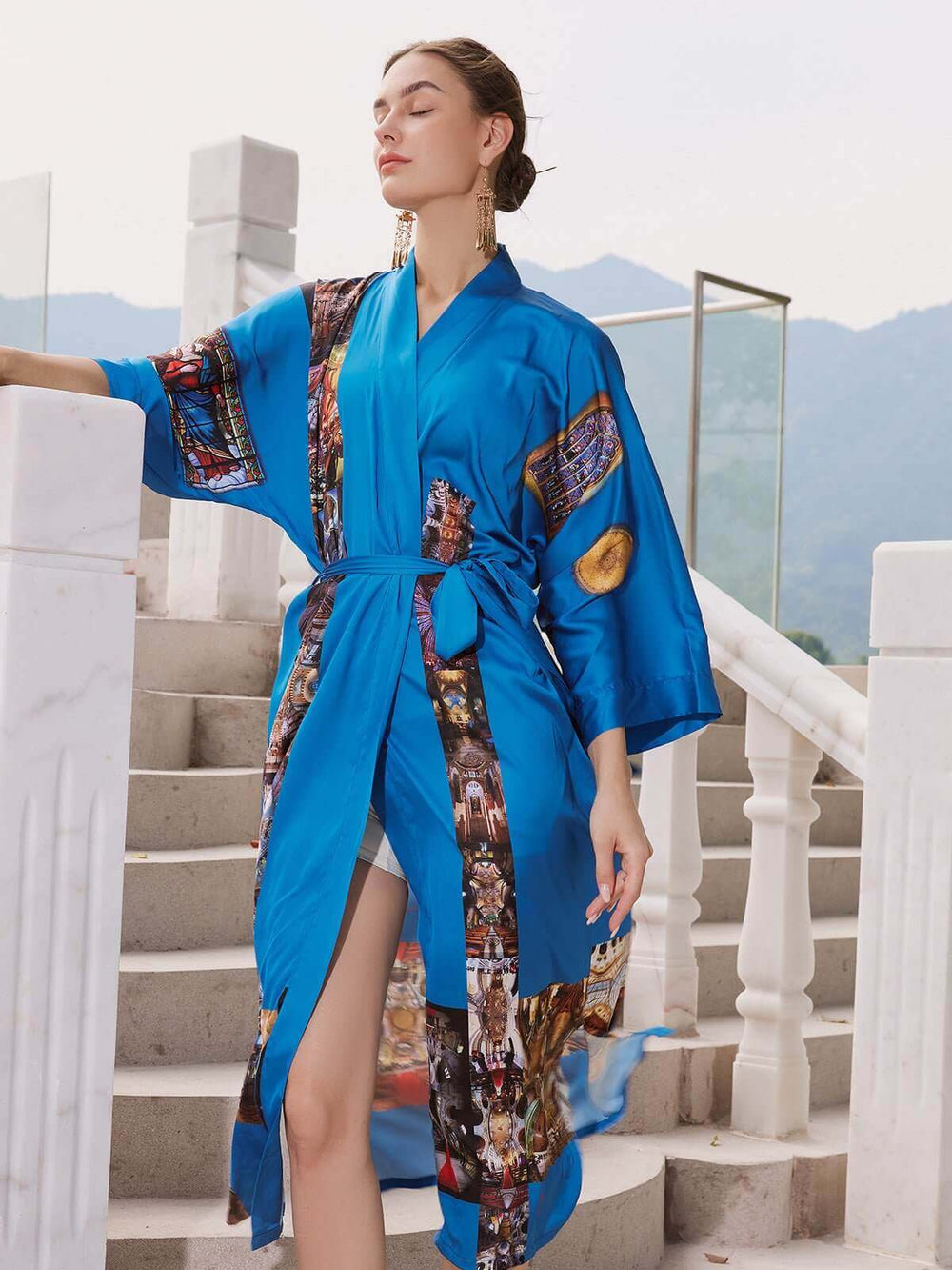 A model wearing a vibrant blue Paris Cathedral Kimono Robe, showcasing its luxurious design and silky comfort.