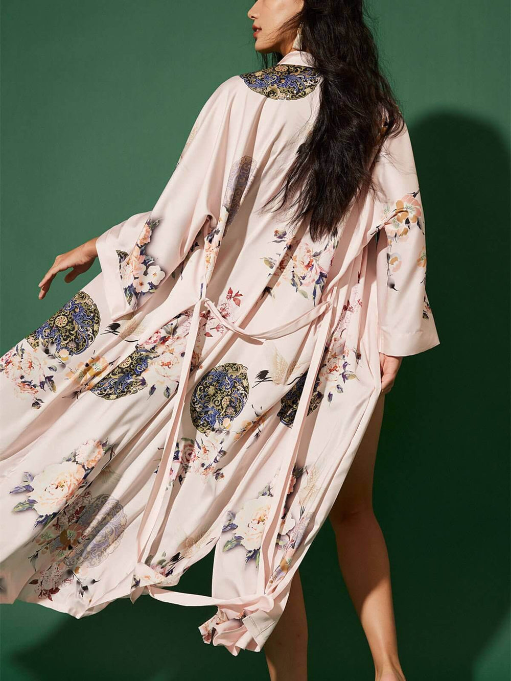 Woman wearing a Garden Crane Blush Kimono Robe with floral prints, showcasing luxury and elegance.