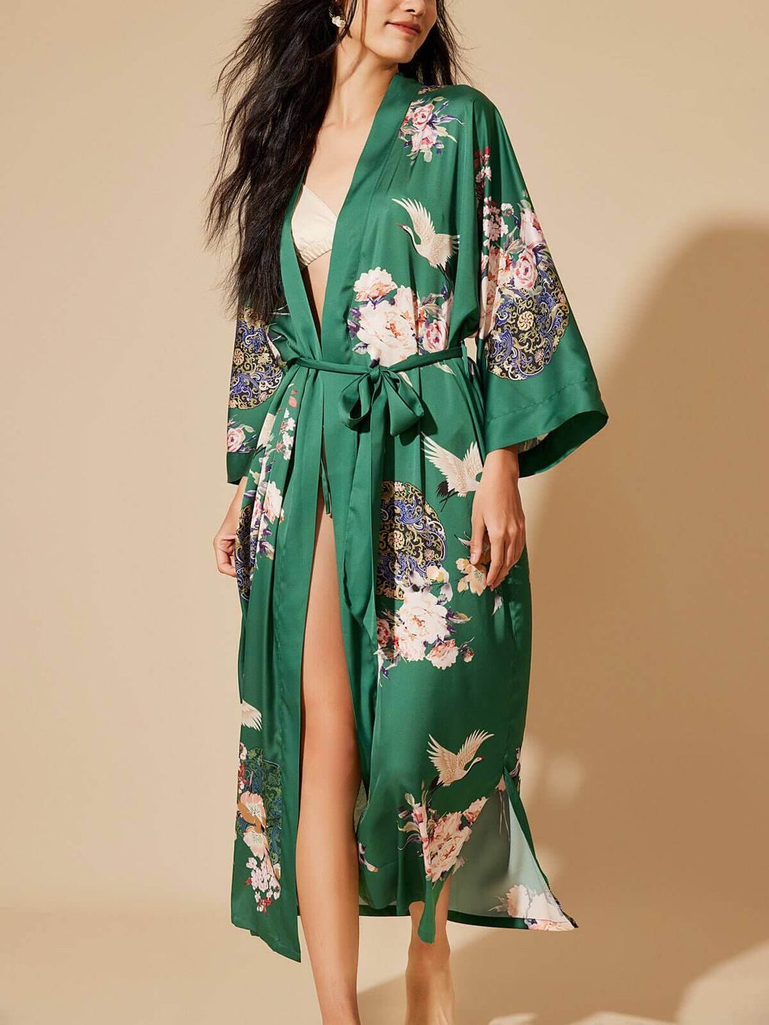 Woman modeling a luxurious Garden Crane Green Kimono Robe with floral designs and a chic silhouette.