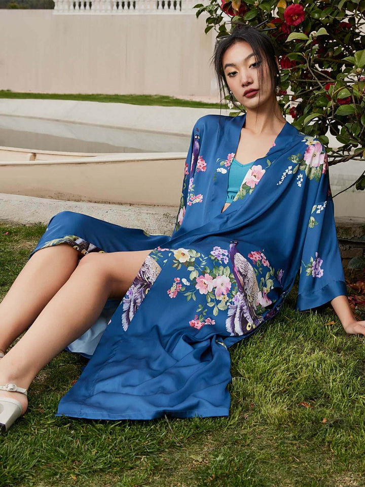 Model wearing a Peacock Blue Kimono Robe with floral prints, showcasing luxury and comfort in an outdoor setting.