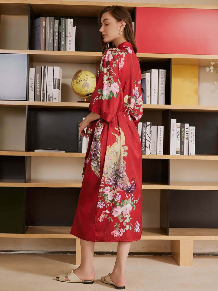 Peacock Red Kimono Robe featuring floral patterns, displayed elegantly in a cozy library setting.