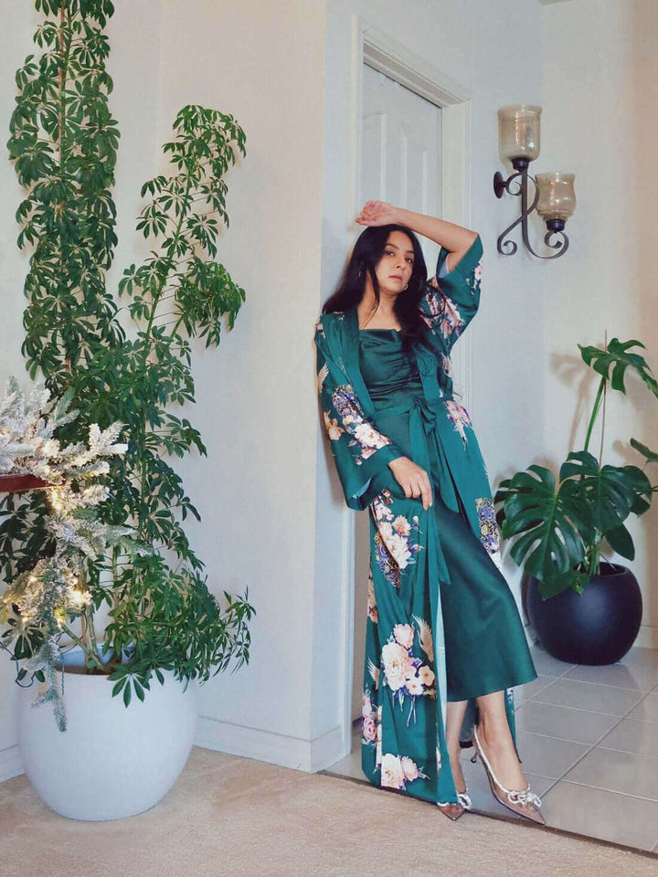 Woman modeling a Garden Crane Green Kimono Robe in a stylish interior with elegant plants.