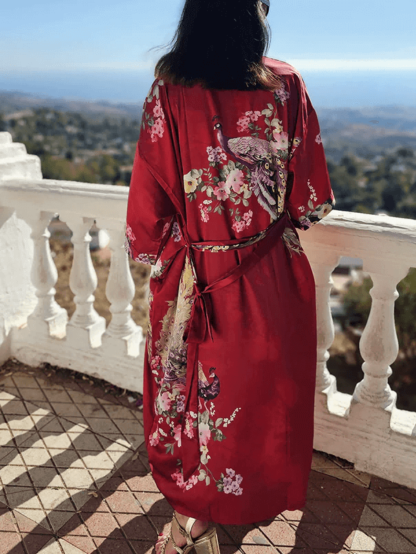 Woman wearing a Peacock Red Kimono Robe with jungle animal prints, enjoying a scenic view.