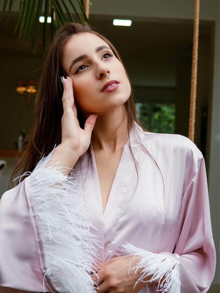 Model wearing a luxurious Pink Feather Bridal Robe, showcasing its elegant design and soft pink fabric.