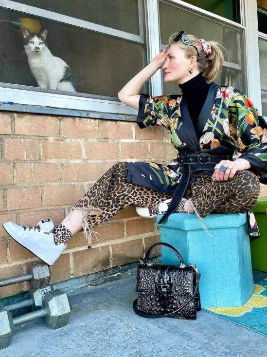 Woman in Short Kimono Robe Black Leopard lounging in a stylish pose with a cat in a window.