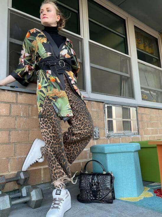 Fashionable woman in a Short Kimono Robe Black Leopard and stylish sneakers, exuding luxury and elegance.