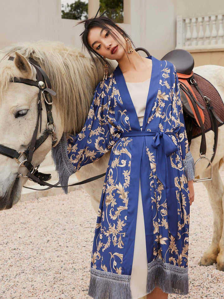 Model wearing a Tassels Blue Kimono Robe next to a white horse, showcasing luxury and elegance in a serene setting.