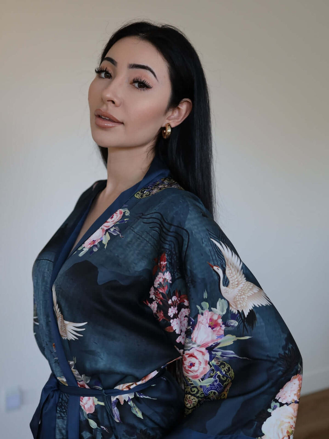 A model wearing a Short Kimono Robe Crane, showcasing luxurious floral prints and elegant style.